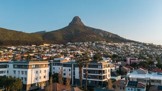 Cape Town suburb with Lion’s Head mountain in the background under a clear evening sky.