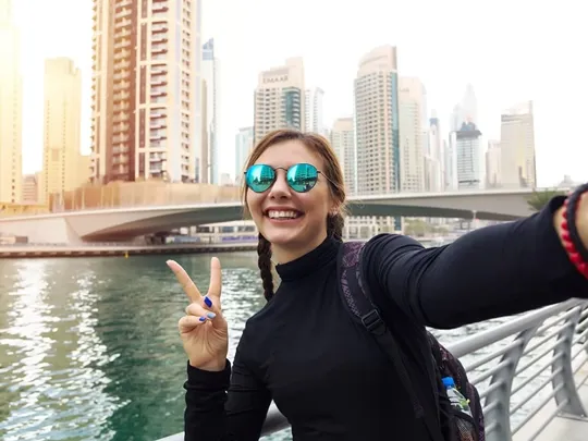 Smiling teenage student taking a selfie in a modern UAE city, symbolising flexible, student-led learning