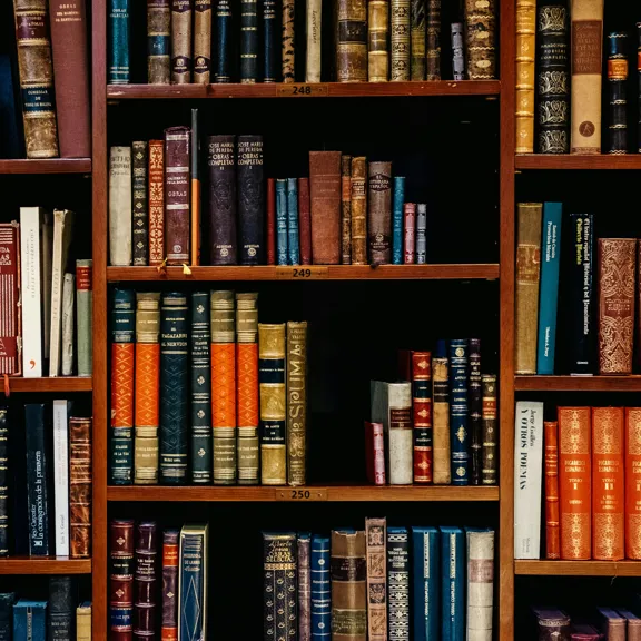 A photograph of lots of old books on a bookshelf.