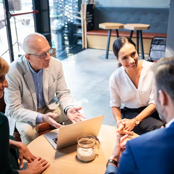 Four professionals having a collaborative meeting in a modern workspace.