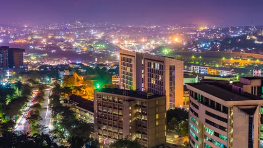Night-time cityscape of Kampala with illuminated buildings and streets