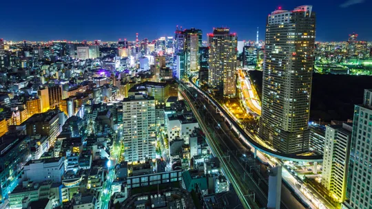Tokyo city lights and high-rise buildings at night with visible expressway and skyline