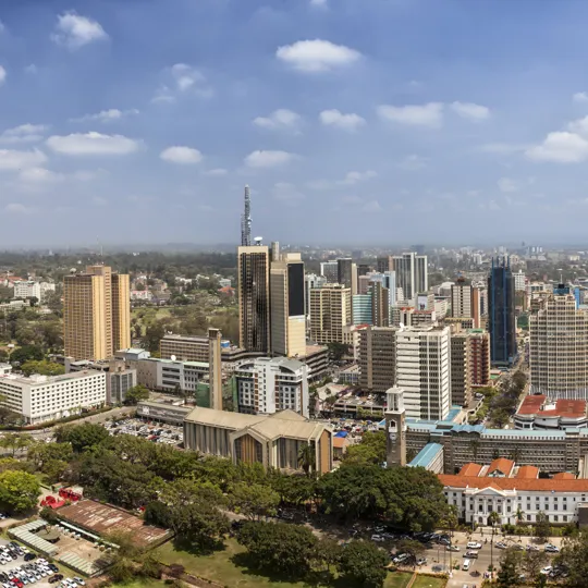 Nairobi cityscape with high-rise buildings, green spaces and blue skies