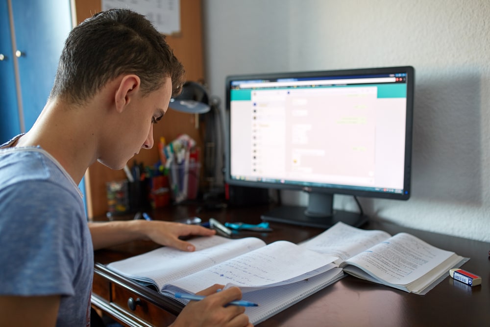 Teenager homeschooling in Qatar using a combination of online learning and text books